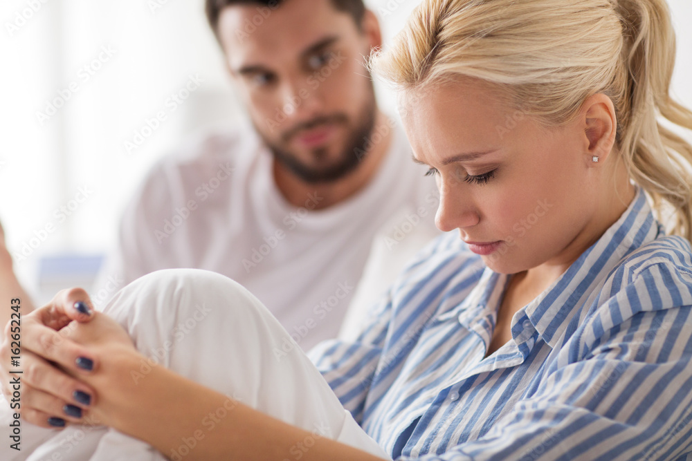 unhappy couple having conflict in bed at home