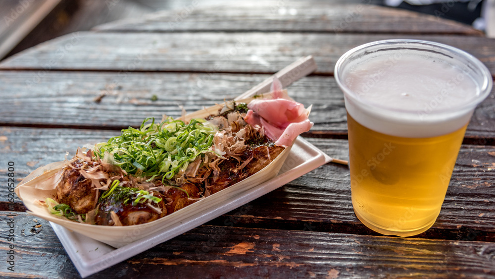 Okonomiyaki street food and a glass of beer in Osaka, Japan Okonomiyaki street food and a glass of beer in Osaka, Japan
