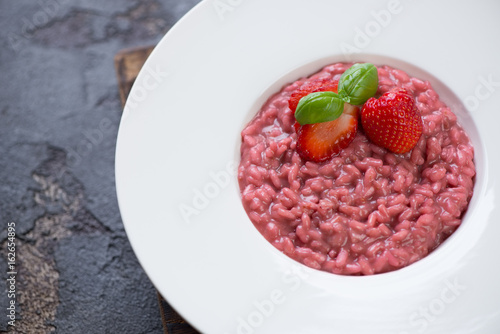 Closeup of a white plate with strawberry risotto, selective focus, studio shot