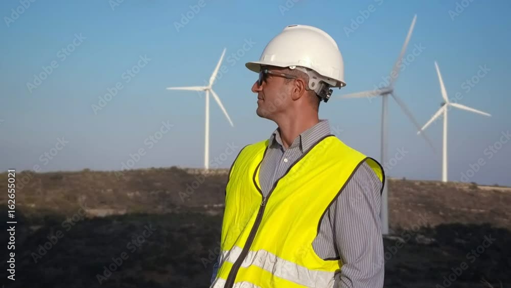 Employee of wind power on the background of windmills Employee of wind power on the background of windmills