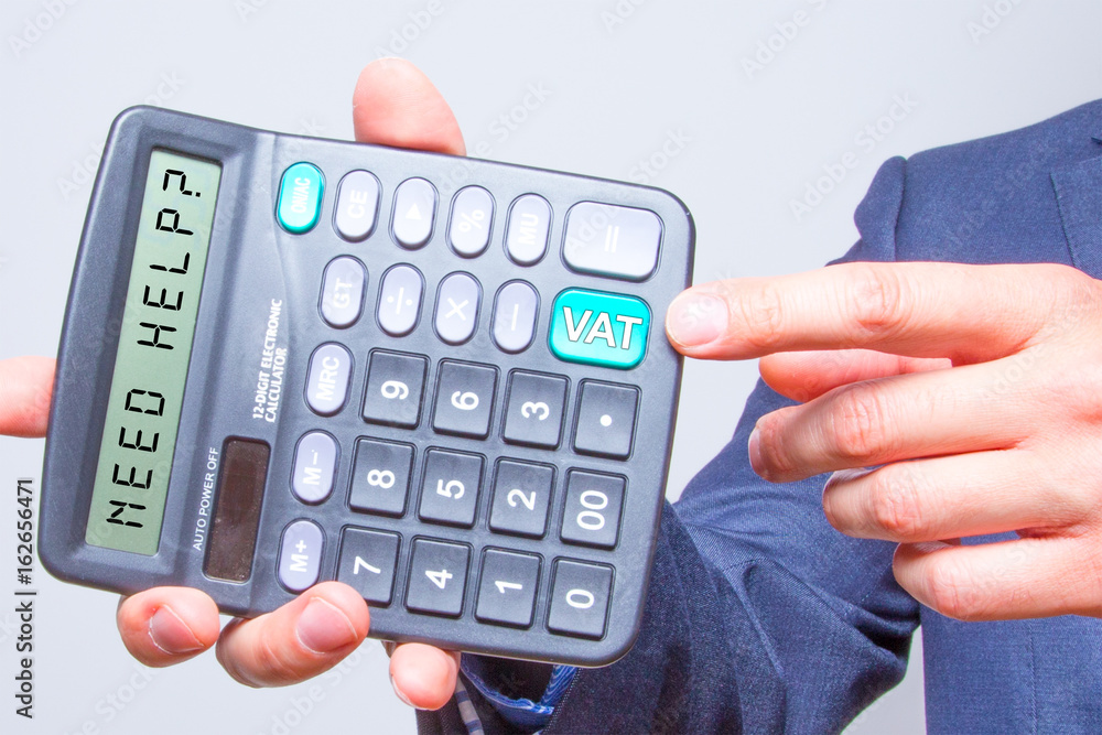 Young businessman pointing on calculator.Need Help? Vat Sign. Taxes business concept Young businessman pointing on calculator.Need Help? Vat Sign. Taxes business concept