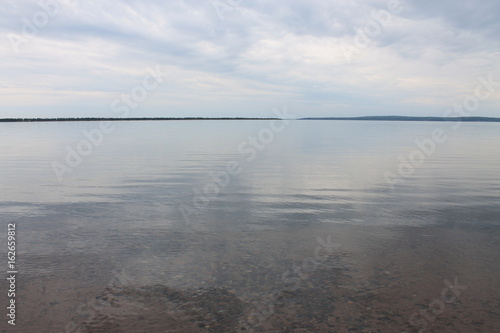 water river stones brown lake shore brown dirt trees green leaves earth