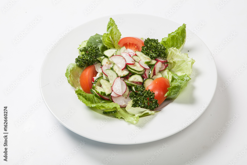 Salad with tomatoes and cucumbers, radishes on the plate