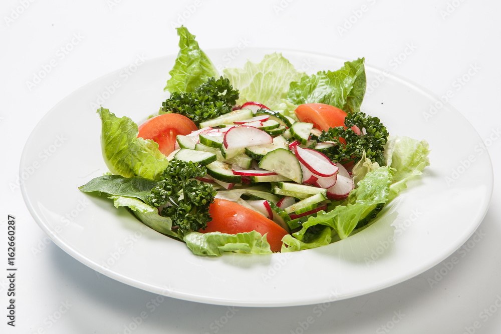 Salad with tomatoes and cucumbers, radishes on the plate Salad with tomatoes and cucumbers, radishes on the plate