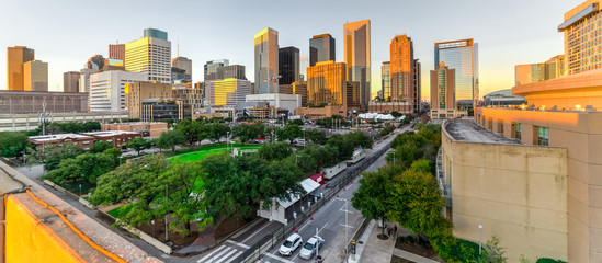 Aerial view downtown Houston illuminated at sunset with green city park and modern skylines light. The most populous city in Texas, fourth-most in United States. Architecture and travel background.