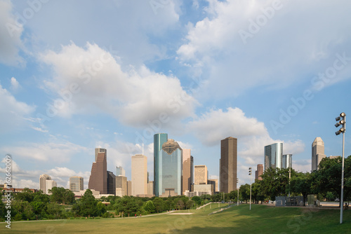 Downtown Houston at sunset with people exercising in distant. Green park lawn and modern skyline. View from Eleanor Tinsley Park. Its fourth-most largest city in US. Architecture and travel background photo