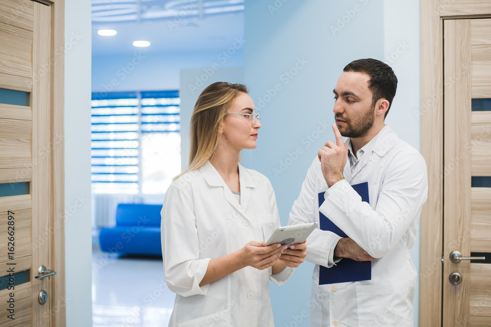 Two doctors discussing diagnosis while walking Two doctors discussing diagnosis while walking
