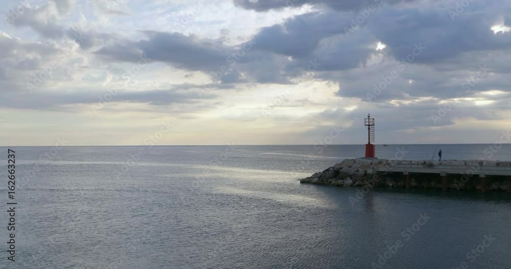Red metal lighthouse at entrance to small harbor of Cattolica in the Adriatic coast at sunrise, Italy. Red metal lighthouse at entrance to small harbor of Cattolica in the Adriatic coast at sunrise, Italy.