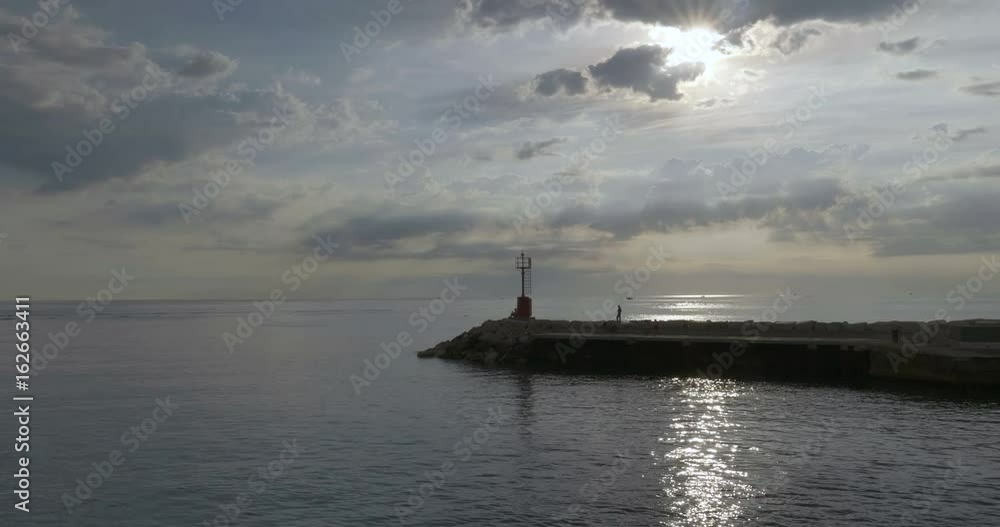 Red metal lighthouse at entrance to small harbor of Cattolica in the Adriatic coast at sunrise, Italy. Red metal lighthouse at entrance to small harbor of Cattolica in the Adriatic coast at sunrise, Italy.