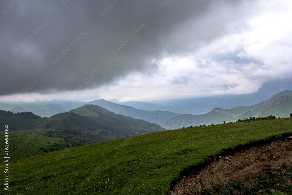 Горный пейзаж, красивый вид на живописное ущелье, облачное небо над горами, дикая природа и горы Северного Кавказа