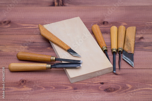 Tool kit for woodcarving. Knives for carving on wooden background