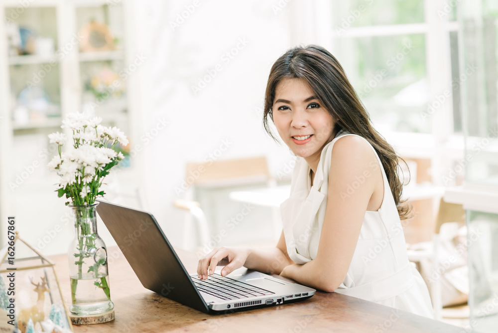 Portrait of happy beautiful young coonfident Asian woman smile while working with laptop indoor Portrait of happy beautiful young coonfident Asian woman smile while working with laptop indoor