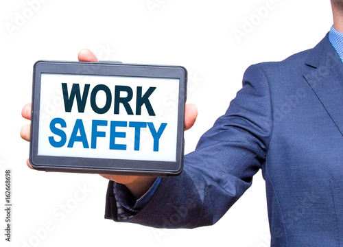 Businessman hand holding tablet with WORK SAFETY text sign. Isolated on white. Business concept. Stock photo