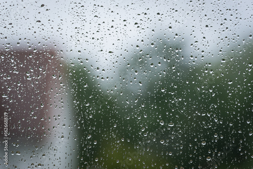 Am Fenster sammeln sich Regentropfen auf der Scheibe
