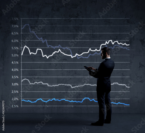 Businessman with smartphone standing over diagram background. Business, finance, investment concept.