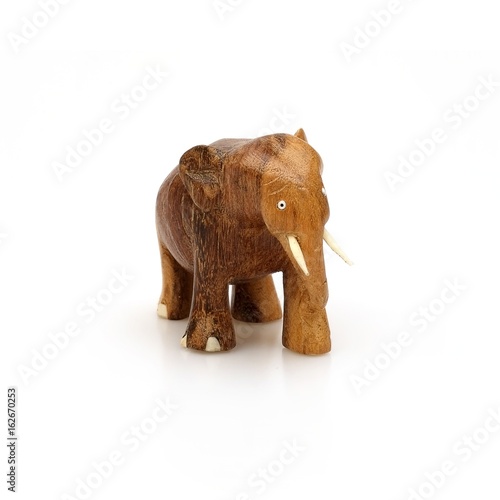 Wooden souvenir elephant made of wood and ivory on a white background