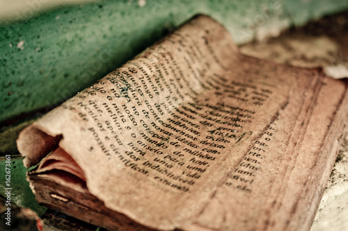 Old and torn bible page showing  biblical passages written in portuguese photo