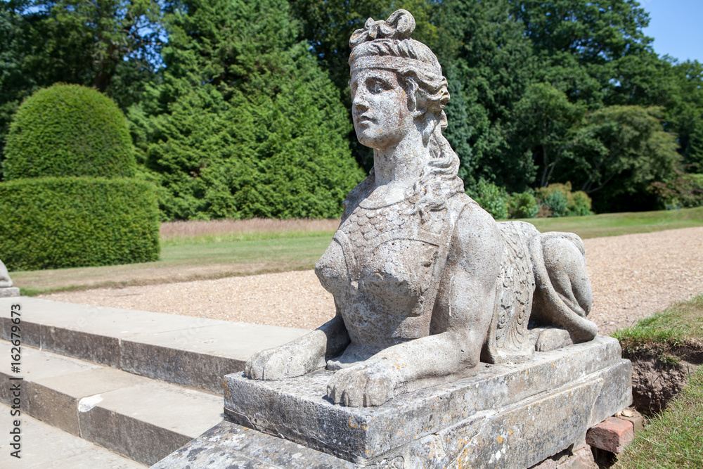 Classical sphinx statue. Woman head with lion body. Ornamental stone garden statue