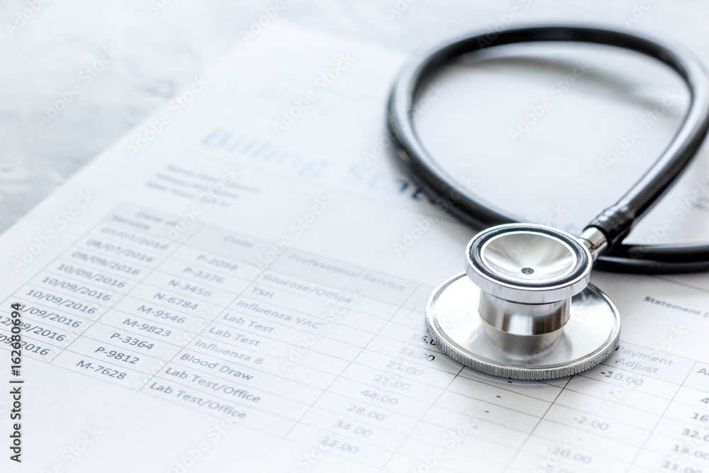 stethoscope, billing statement for doctor's work in medical center stone background stethoscope, billing statement for doctor's work in medical center stone background
