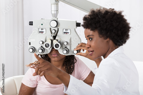 Fototapeta Naklejka Na Ścianę i Meble -  Optometrist Doing Sight Testing For Patient