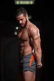 Muscular Model Flexing Muscles In Gym