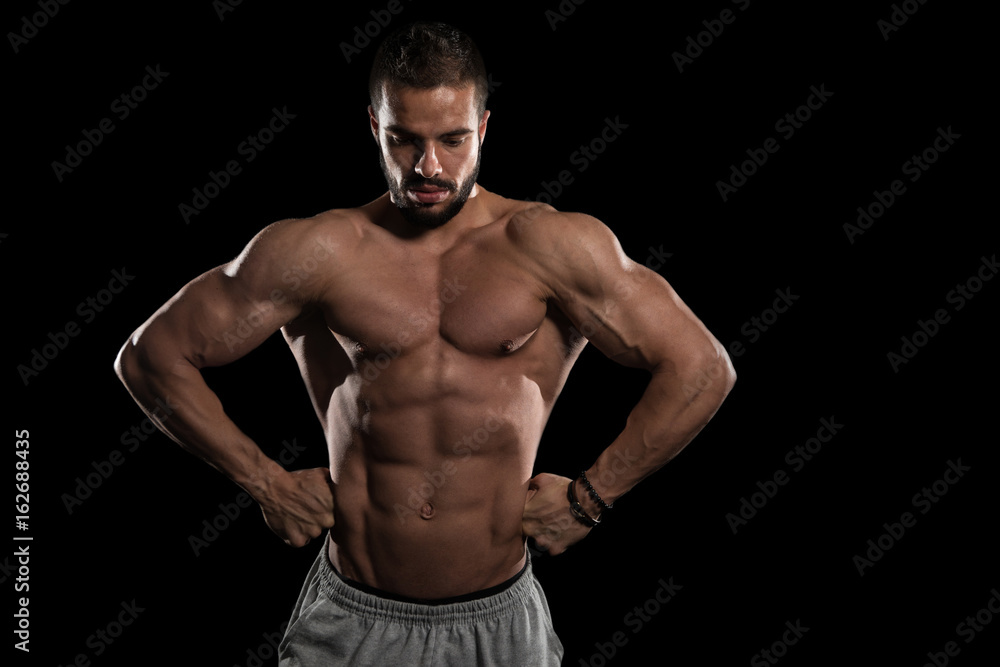 Muscular Model Flexing Muscles On Black Background