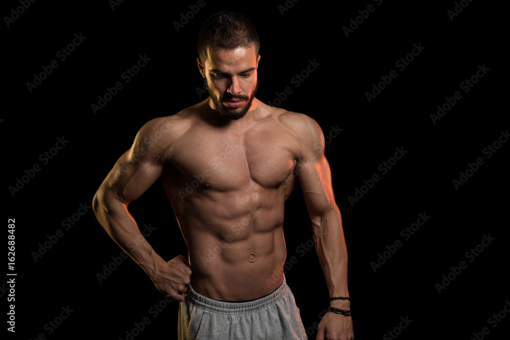 Muscular Man Flexing Muscles On Black Background