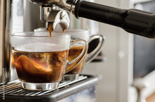 Fresh coffee flowing from espresso machine