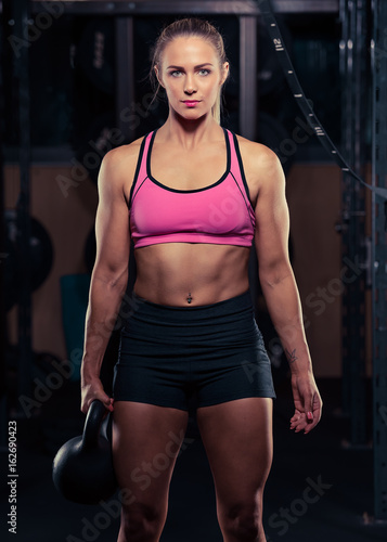 Fitness female holding a kettlebell in the gym during a workout