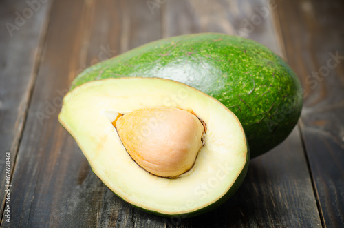 Half of avocado fruit on wooden background,Healthy food