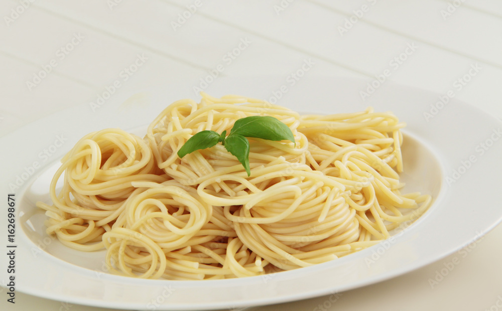 Spaghetti pasta with basil herbs. White background. Close up view. Spaghetti pasta with basil herbs. White background. Close up view.