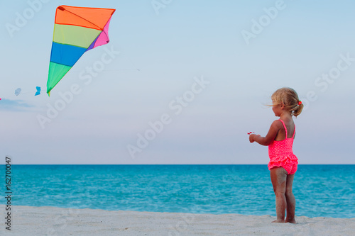 Little girl flying a kite on beach
