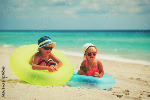 cute little boy and girl play on beach