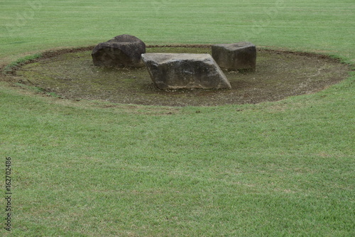 公園の芝生と石のベンチ