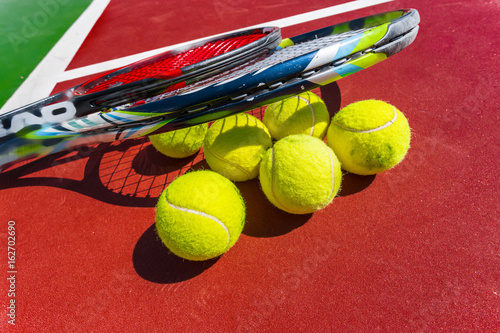 Tennis balls and racket on the grass court © fotofabrika