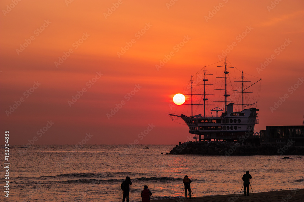 South Korea. Silhouette of people taking photos and sunrise at Jeongdongjin in Gangwon Province