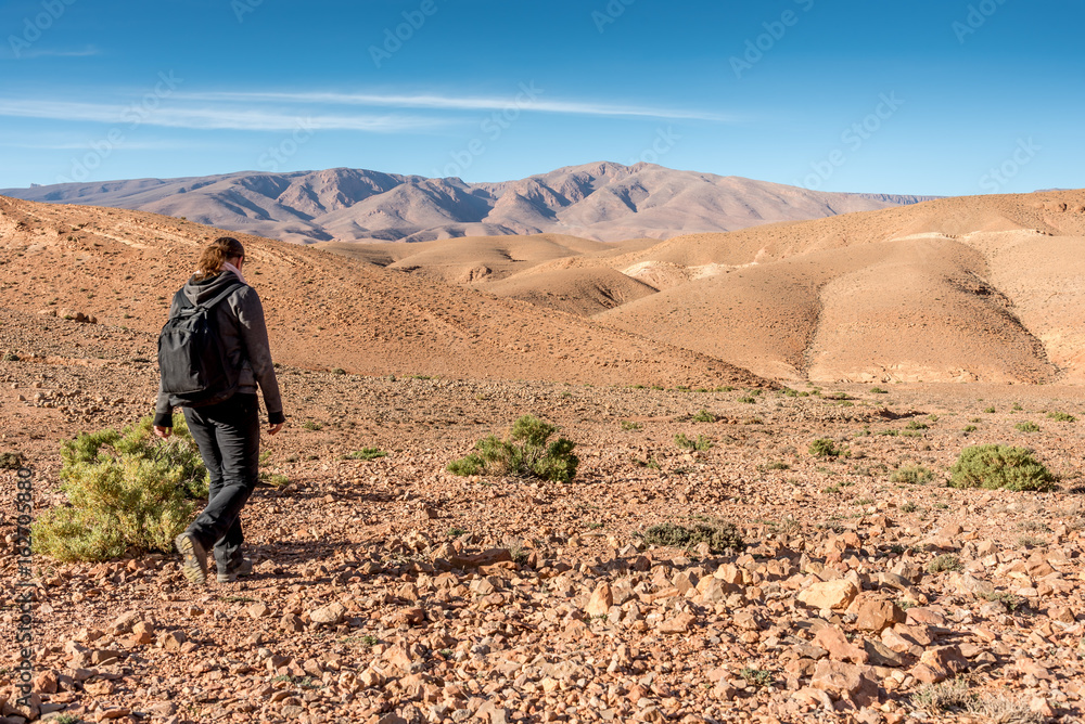 Hiker walking through plain in High Atlas mountains, Morocco