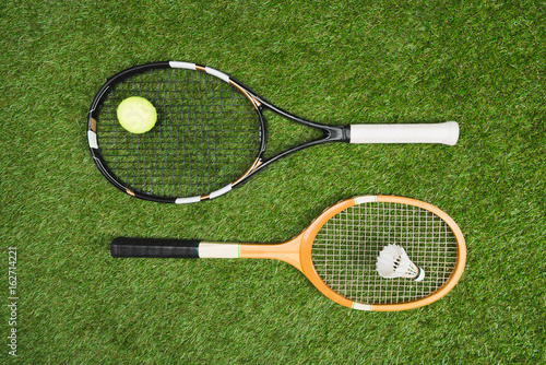 top view of tennis and badminton equipment lying on grassland