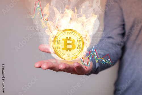 Human Hand Bruning Golden Bitcoin Dropping Prices photo
