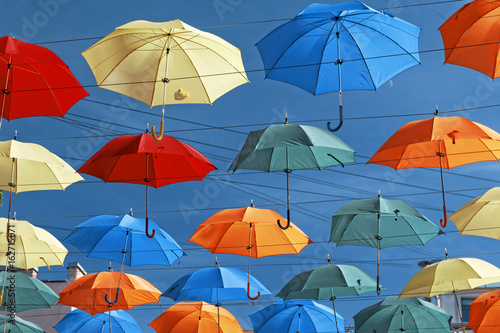 Multi-colored umbrellas in sky above the street. Alley floating umbrellas © sebos