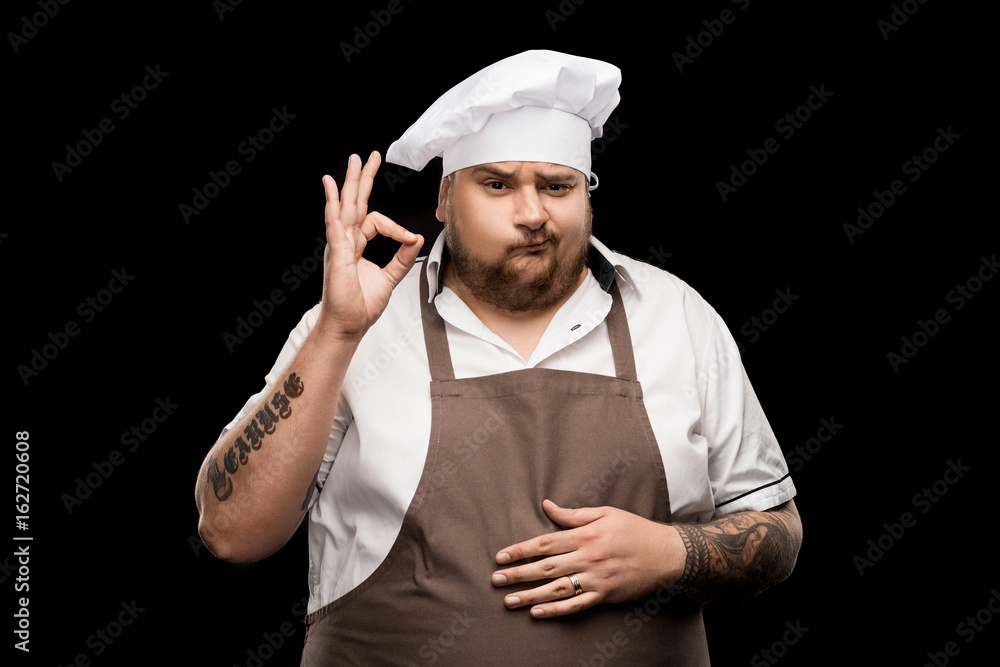 professional chef in hat and apron showing ok sign isolated on black professional chef in hat and apron showing ok sign isolated on black