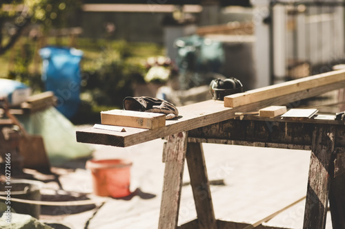 Wooden planks and gloves in yard during sunny day photo