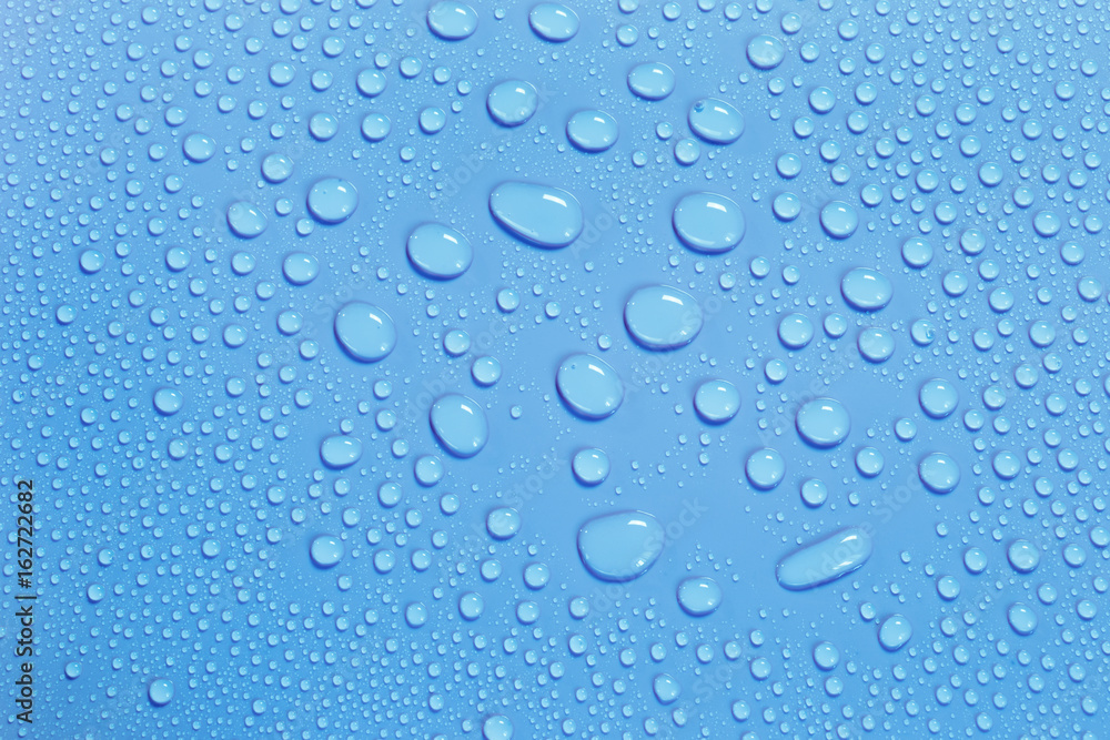 Water drops on smooth surface, blue background