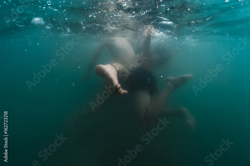 Couple plays underwater. Performs contact imrovisation dance in the water © Dudarev Mikhail