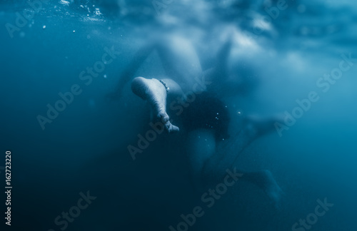 Couple plays underwater. Performs contact imrovisation dance in the water © Dudarev Mikhail