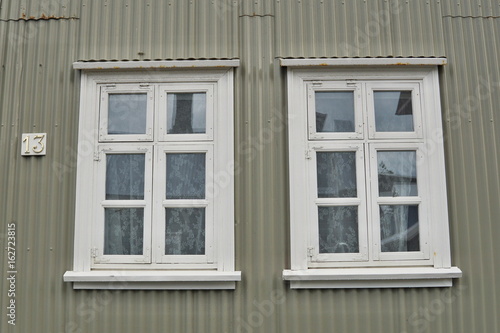 Typical Icelandic house facade in gray color made of corrugated iron and with white wooden windows in Reykjavik  the capital city of Iceland  