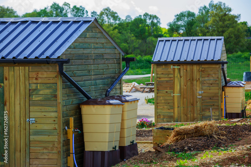 Obraz na plátne Green recovery of rainwater outside in town garden with small wooden cabin