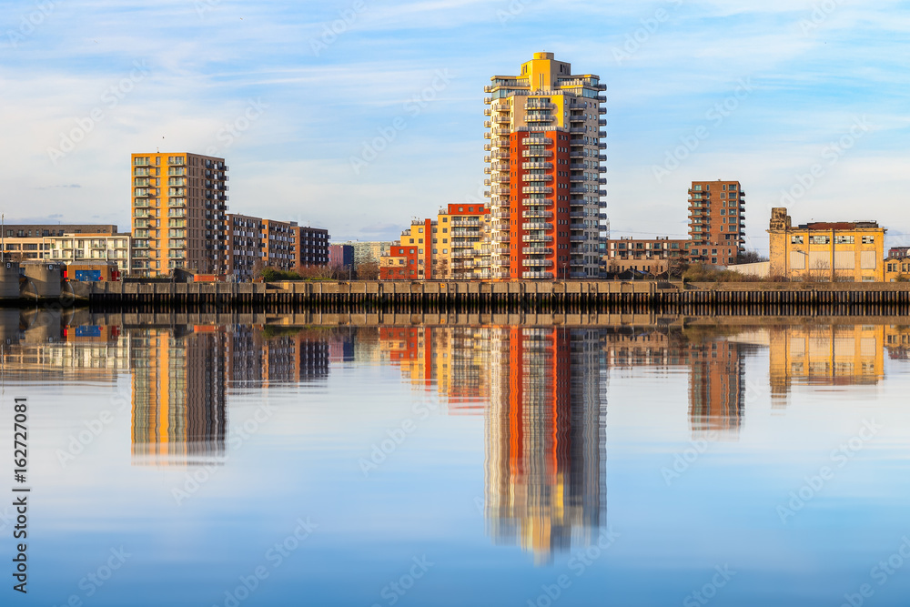 Riverside apartment next to Thames Barrier with its reflection from river Thames