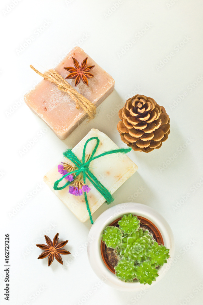 Organic handmade soaps decoration by pinecone, star anise, dry flowers and Succulent plant on white background with copy space Organic handmade soaps decoration by pinecone, star anise, dry flowers and Succulent plant on white background with copy space