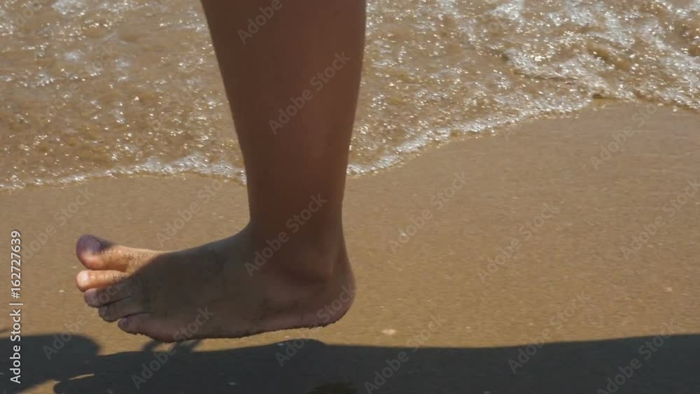 Slow motion of female legs running splashing into water.
Slow motion of female legs running splashing into water.